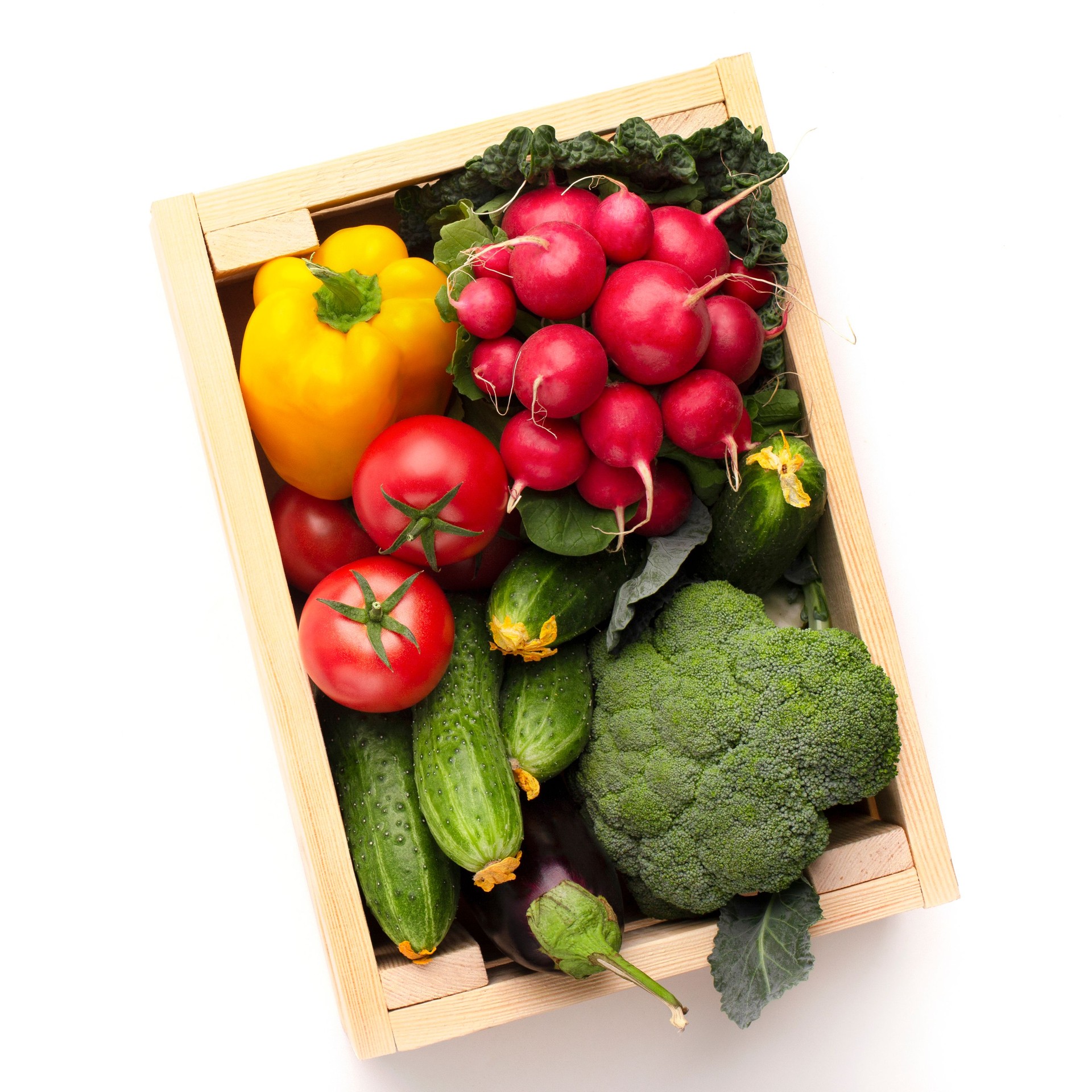 Fresh and organic vegetables in wooden box on white